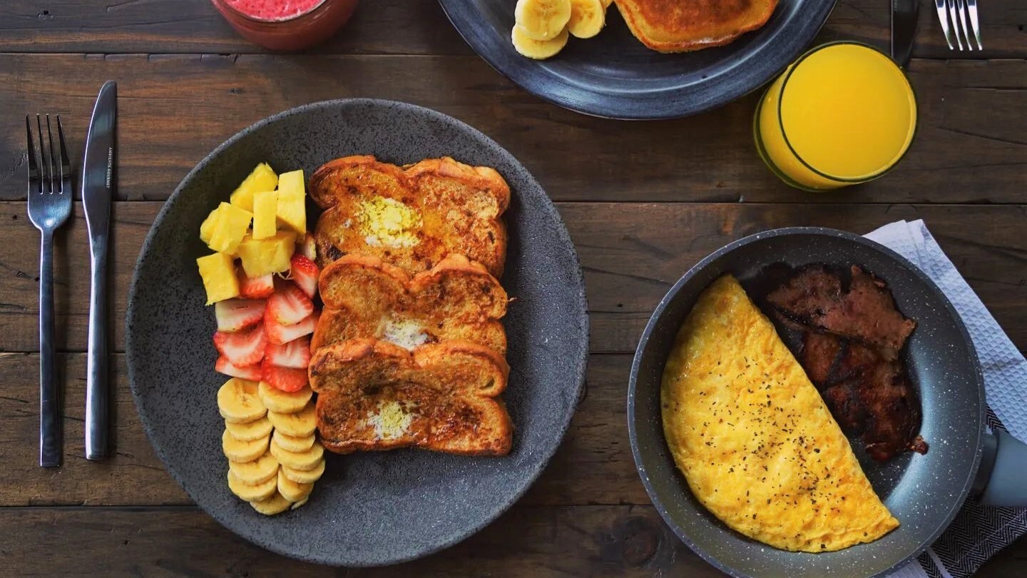 Plato completo de brunch · french toast con frutas frescas, omelette, bacon, jugo de naranja y pancakes