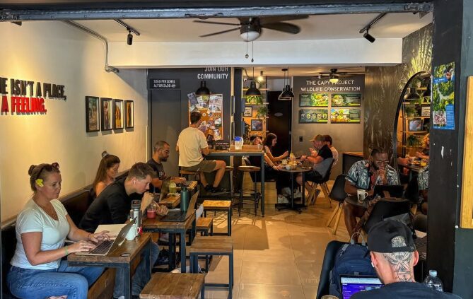 Interior del café · ambiente bohemio con mesas comunales y plantas